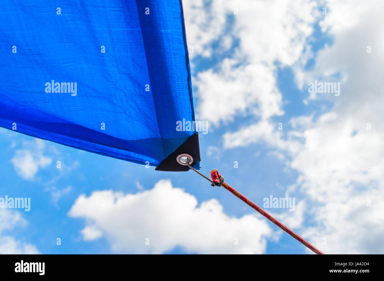 Tende da sole in forma vele su sfondo con cielo nuvoloso. Dettaglio del fissaggio della tenda da sole per il cavo Foto Stock