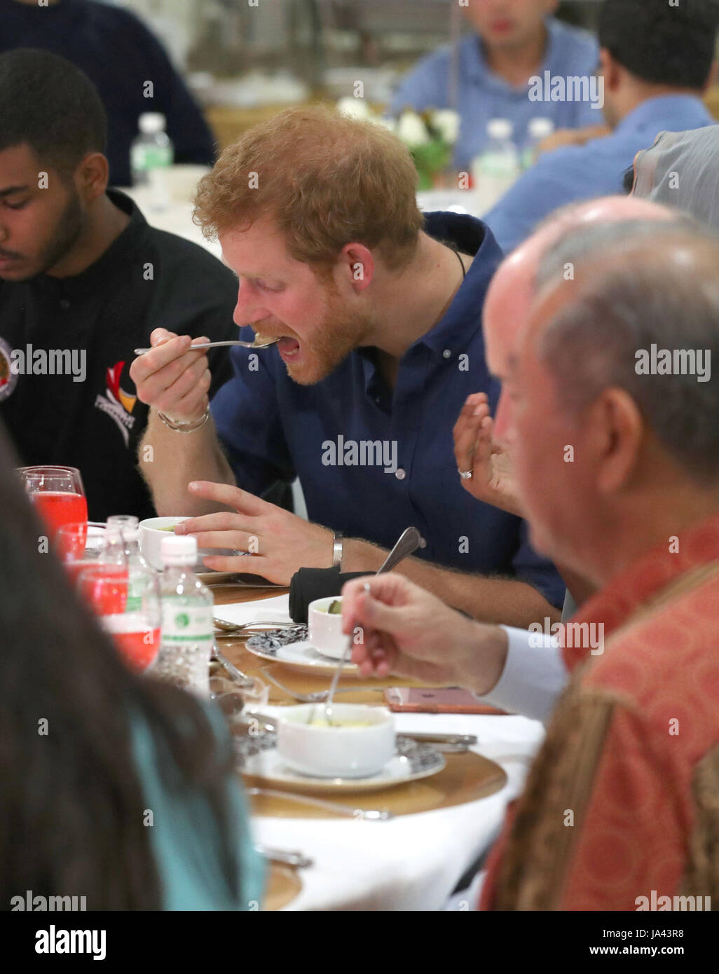 Il principe Harry si siede per iftar, rottura del digiuno, mangiando il porridge al Jamiyah Education Centre in Singapore. Foto Stock