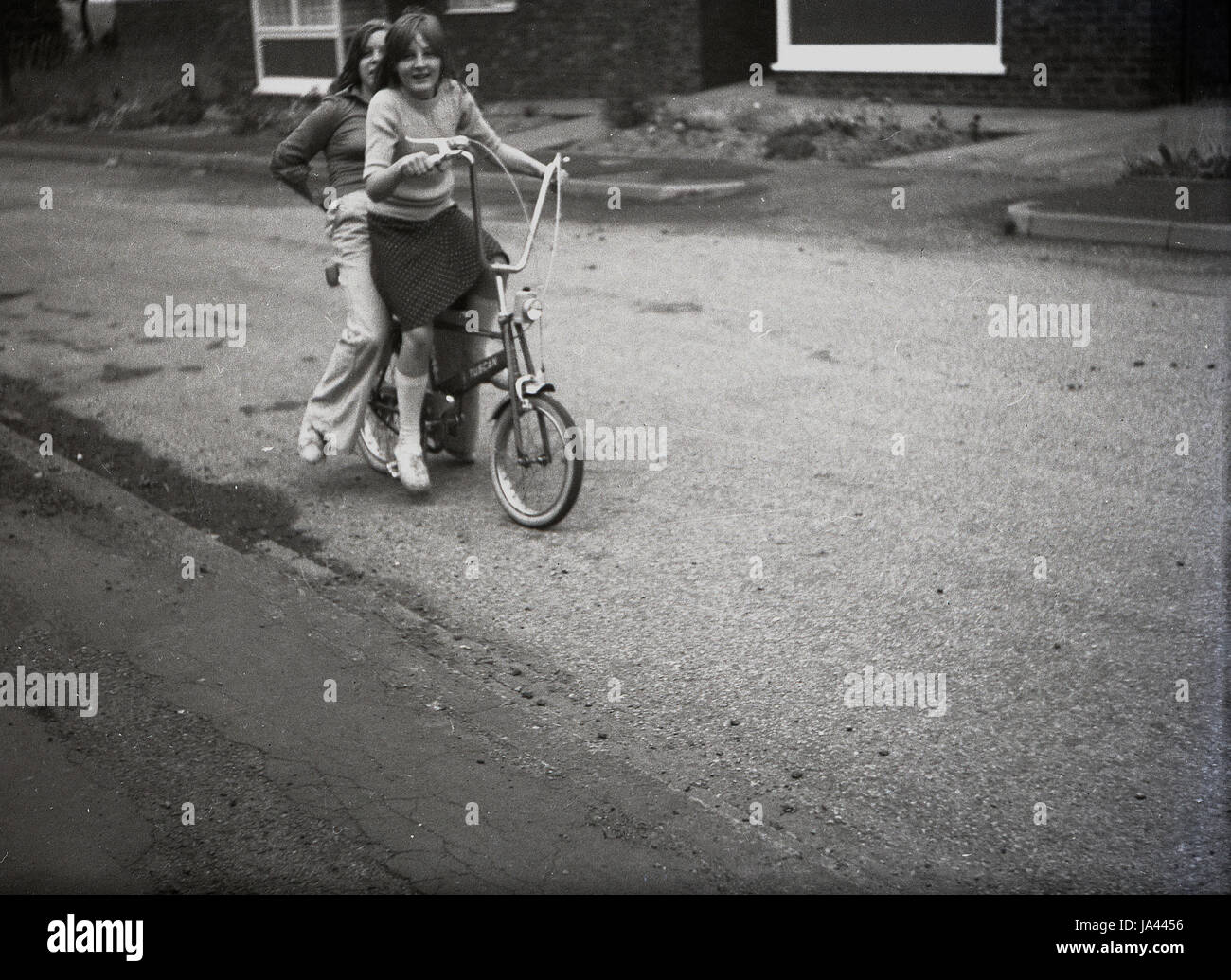 Anni Settanta, storico, due giovani ragazze in sella ad una bici toscana,  un chopper tipo bicicletta con manubrio alto e pneumatici di dimensioni  diverse, un iconico bike di questa epoca Foto stock -