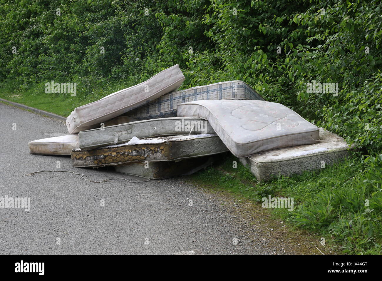 Un carico di materassi oggetto di dumping dal lato di una strada di campagna del Sussex Foto Stock
