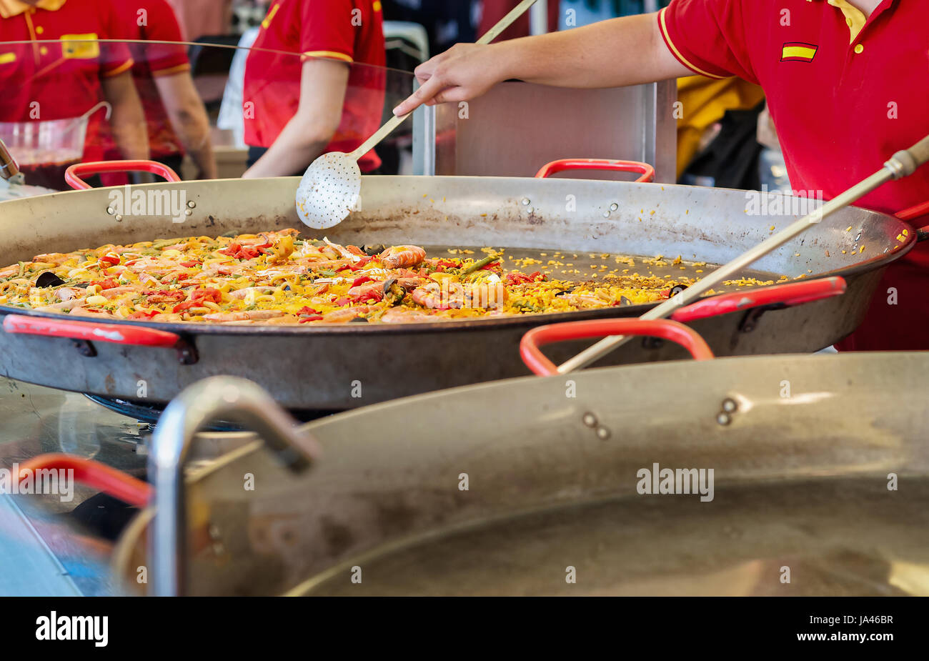 La paella di frutti di mare in una padella per paella a un cibo di strada tradizionale mercato spagnolo paella con pesce e pollo. Foto Stock