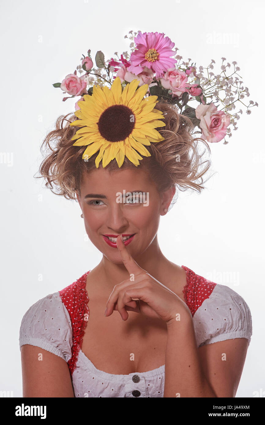 Ritratto di una giovane donna con coppiglia e fiori estivi nei suoi capelli e dirndl bavarese Foto Stock