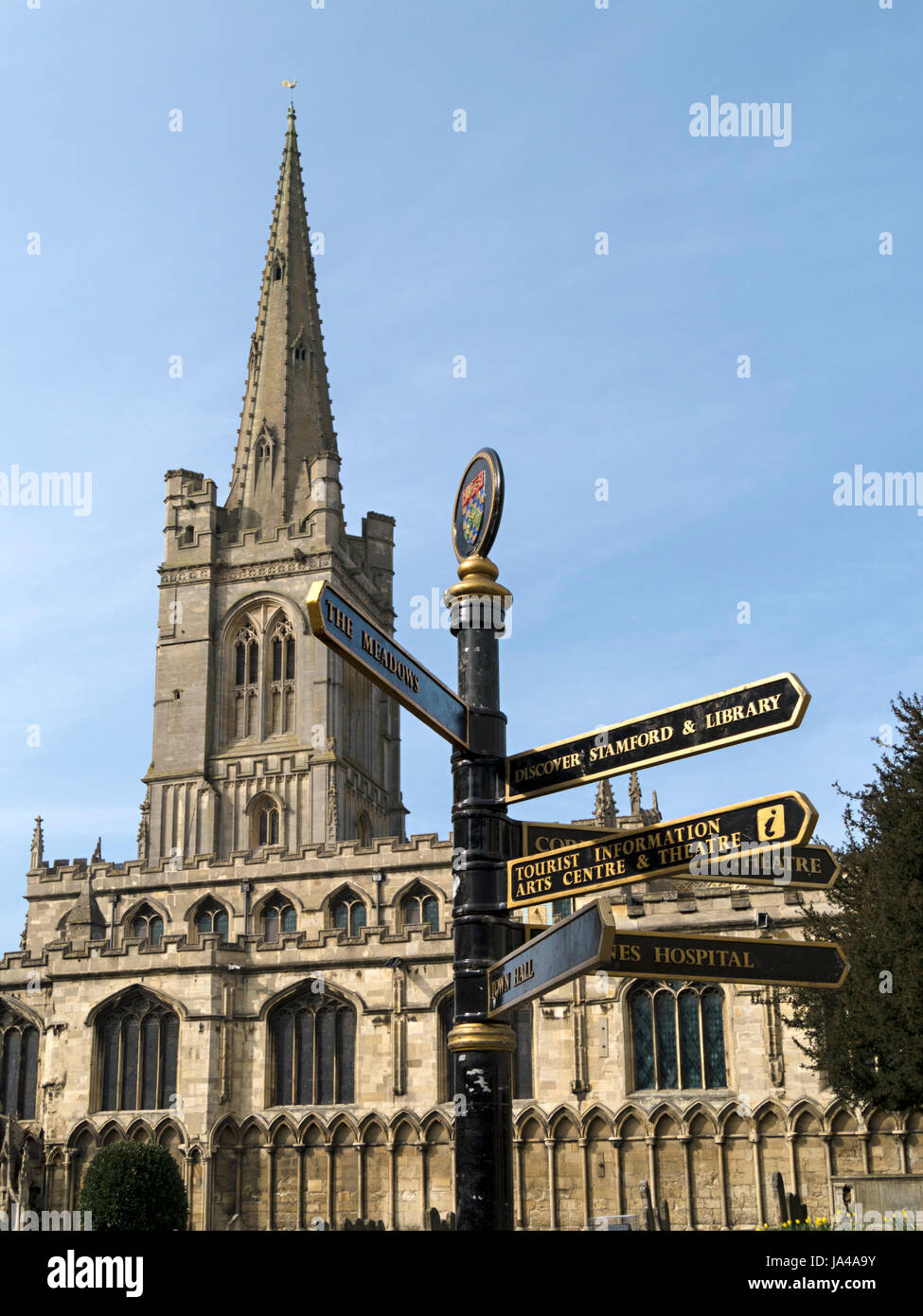 Chiesa di tutti i Santi Stamford con il dito post segno di direzione in primo piano, Red Lion Square, Stamford, Lincolnshire, Inghilterra, Regno Unito. Foto Stock