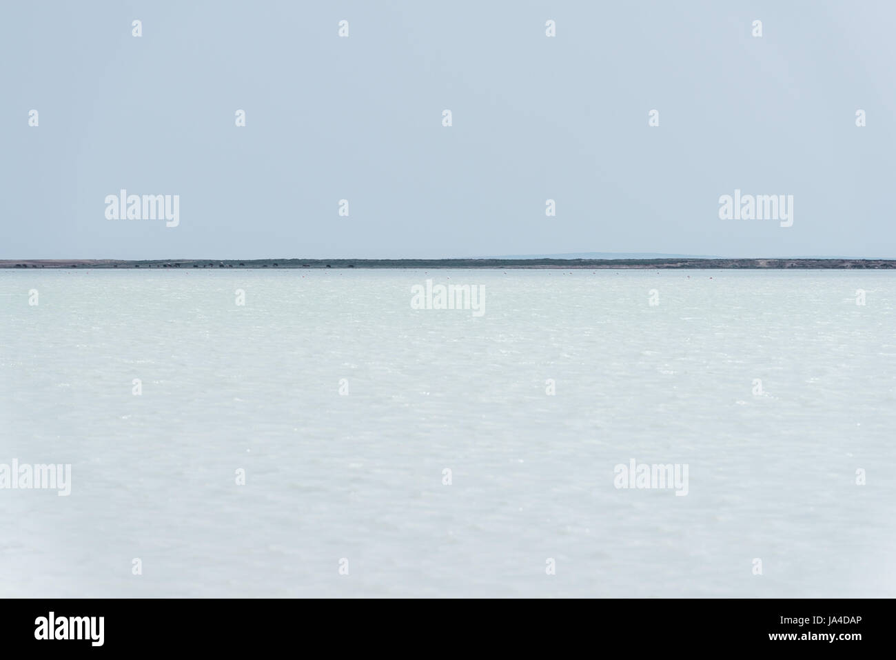 Una scena minimalista con un cielo chiaro, blu acqua e una linea di orizzonte Foto Stock