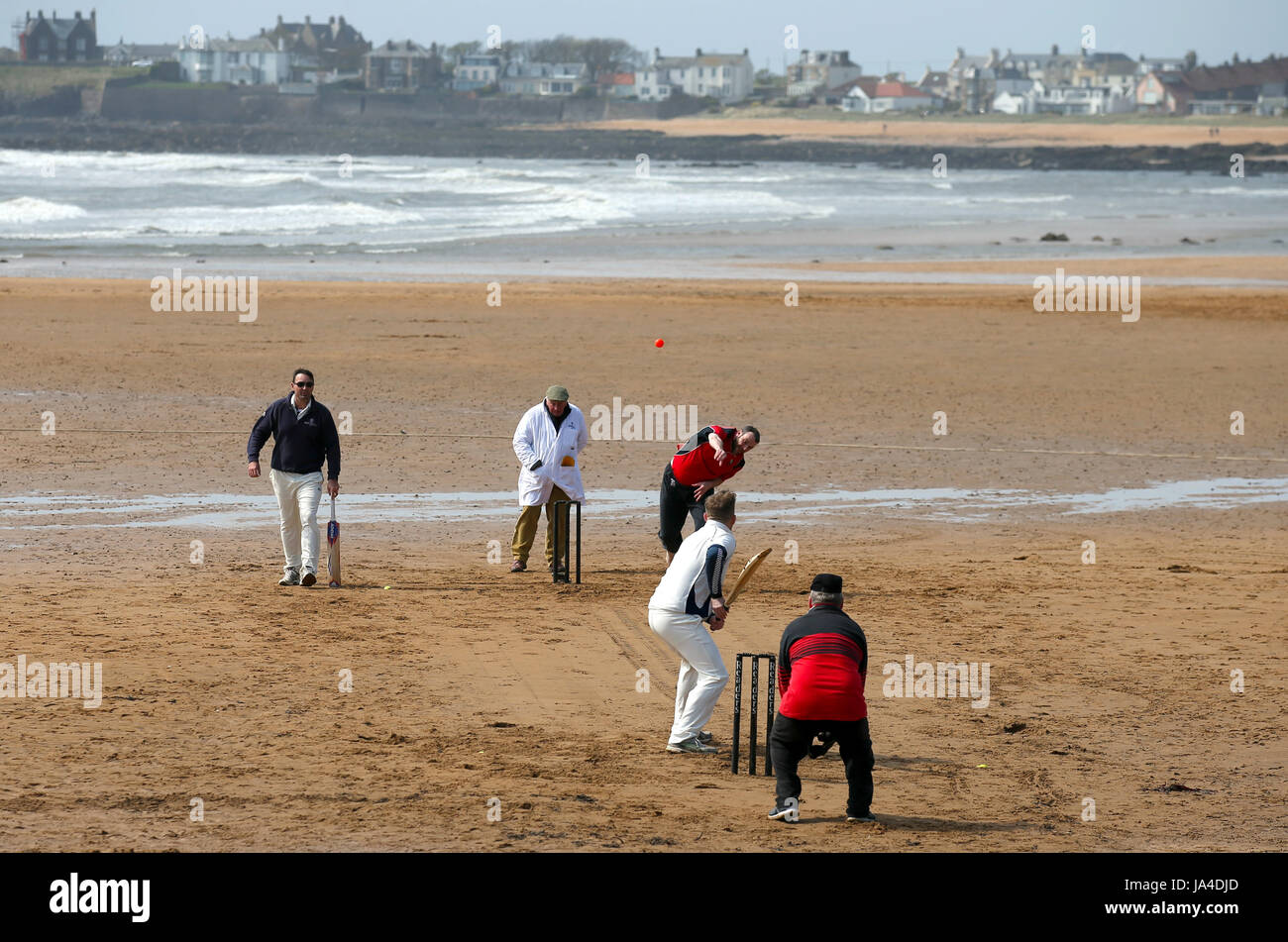 Azione dalla spiaggia partita di cricket in Elie, tra la nave Inn di cricket, in Elie, Fife e fenicotteri eccentrico CC. La nave Inn sono l'unico pub in Gran Bretagna per avere una squadra di cricket con un passo sulla spiaggia. La nave Inn CC stagione dura da maggio a settembre con date delle partite dipende dalla marea. Essi giocano contro una combinazione di opposizione regolari dalla Scozia e touring squadre provenienti da tutto il mondo. Qualsiasi battitore colpendo un sei che atterra in nave Inn beer garden vince la loro altezza in birra e qualsiasi mancata riproduzione di spettatore che le catture a sei nel giardino della birra vince anche loro unaltezza massima Foto Stock