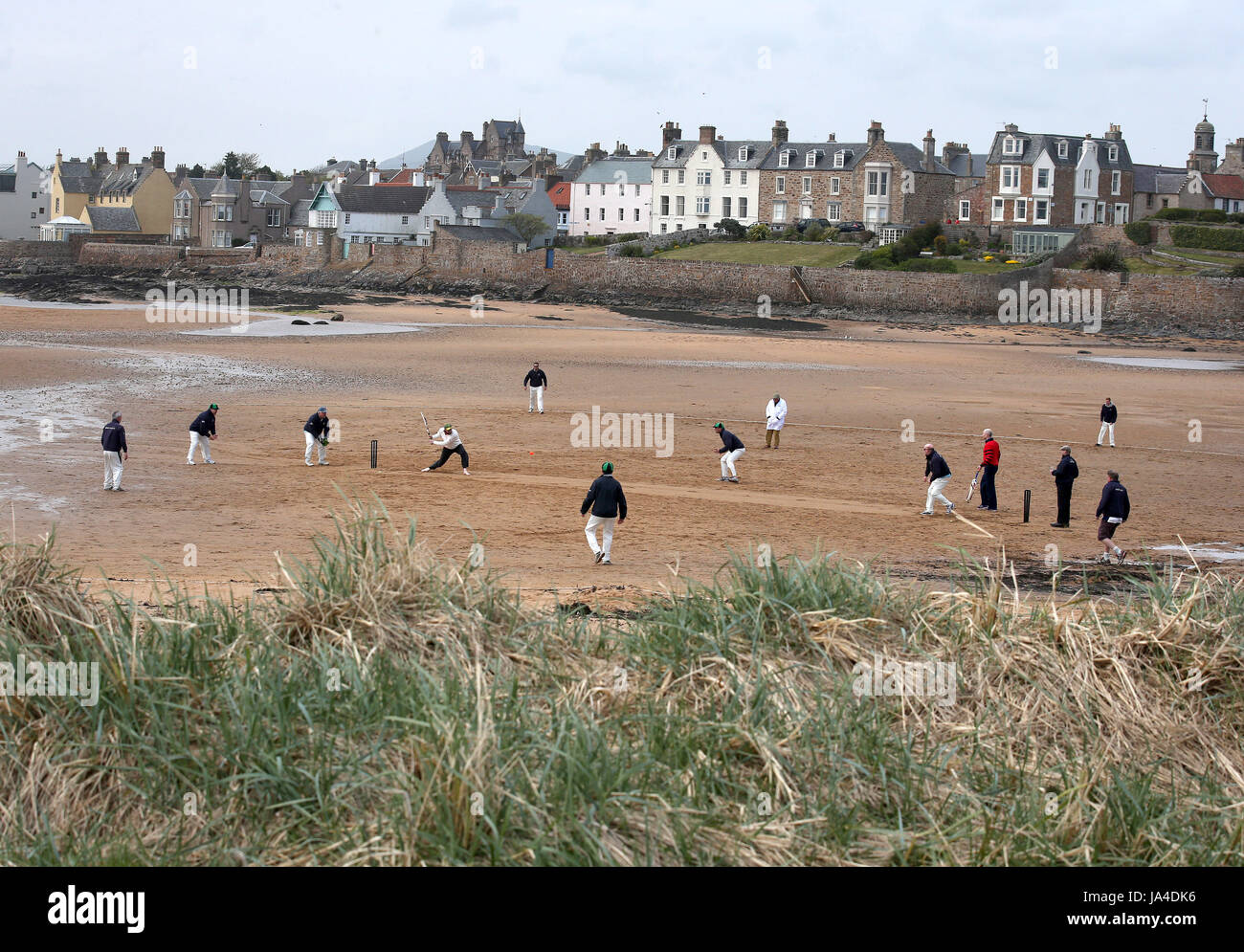 Azione dalla partita di cricket in spiaggia a Elie, tra la squadra di cricket Ship Inn, a Elie, Fife e l'eccentrico Flamingos CC. Lo Ship Inn è l'unico pub in Gran Bretagna ad avere una squadra di cricket con un campo sulla spiaggia. La stagione Ship Inn CC va da maggio a settembre con date di partite che dipendono dalla marea. Giocano contro una combinazione di opposizione regolare dalla Scozia e squadre di turismo da tutto il mondo. Ogni battitore che colpisce un sei che atterra nella birreria all'aperto vince la loro altezza in birra e qualsiasi spettatore che non gioca e che cattura un sei nella birreria all'aperto vince anche la loro coscia Foto Stock