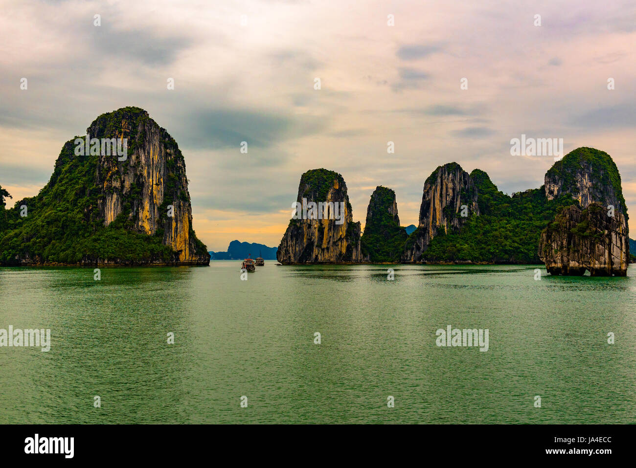 La Baia di Ha Long, Vietnam -- 24 marzo 2016 Tour barche di filo attraverso un passaggio stretto tra le formazioni rocciose nella Baia di Ha Long, Vietnam. Foto Stock