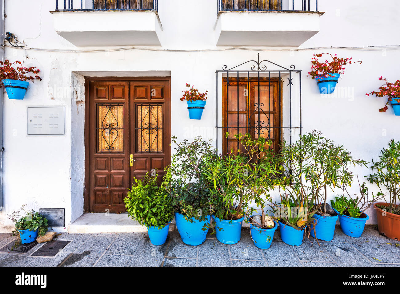 La facciata della casa con fiori in vasi blu in Mijas, Andalusia, Spagna, Europa Foto Stock