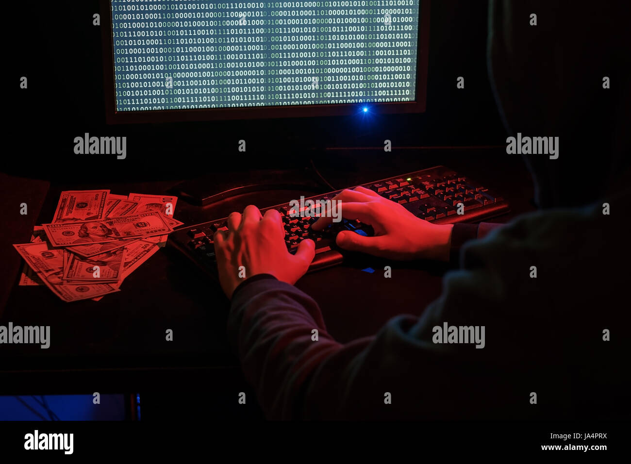 L'uomo nel cofano controlla il codice dannoso sulla tastiera. La criminalità informatica attraverso Internet. Foto Stock