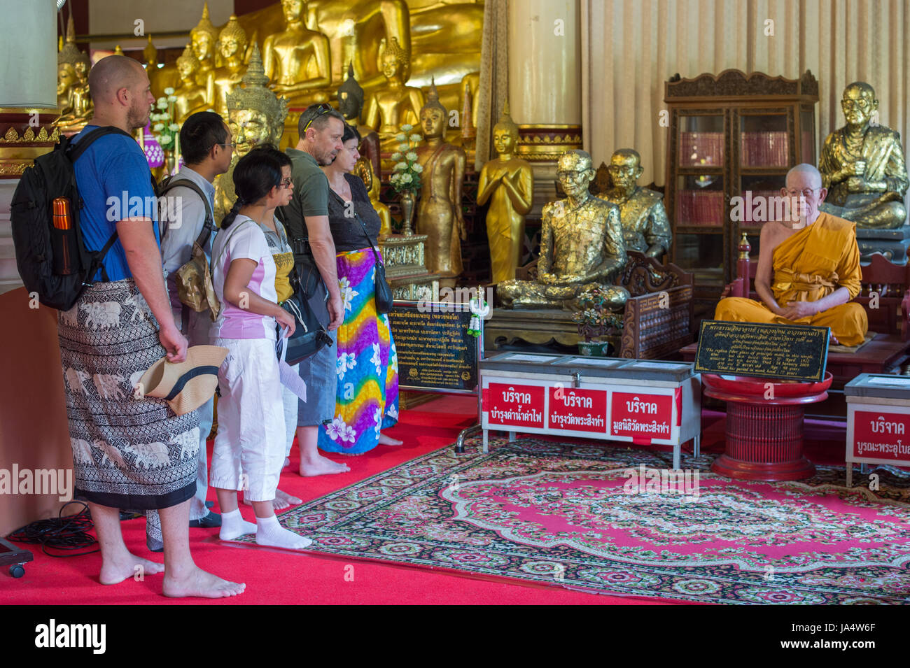 Ai turisti di ammirare una scultura di cera di un monaco di Wat Phra Singh, che è uno dei più famosi templi buddisti in Chiang Mai. Foto Stock