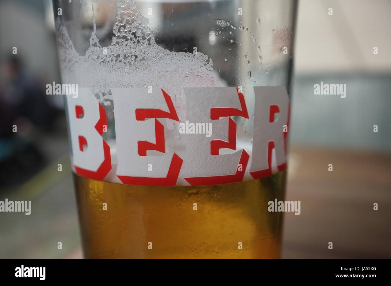 Una pinta di vetro con la parola "birra" su di esso nel giardino esterno di un pub di Oxford, Inghilterra, Regno Unito. Giugno 2, 2017. Foto Stock