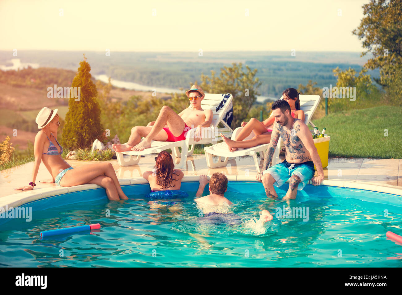 Gruppo giovane godendo in piscina in estate Foto Stock