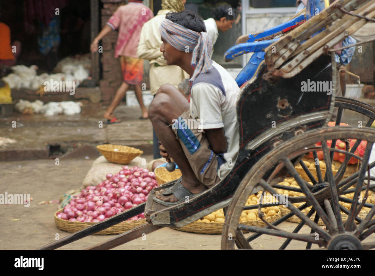 Uomo appoggiato su una mano tirata rickshaw in Kolkata, West Bengal, India. Foto Stock