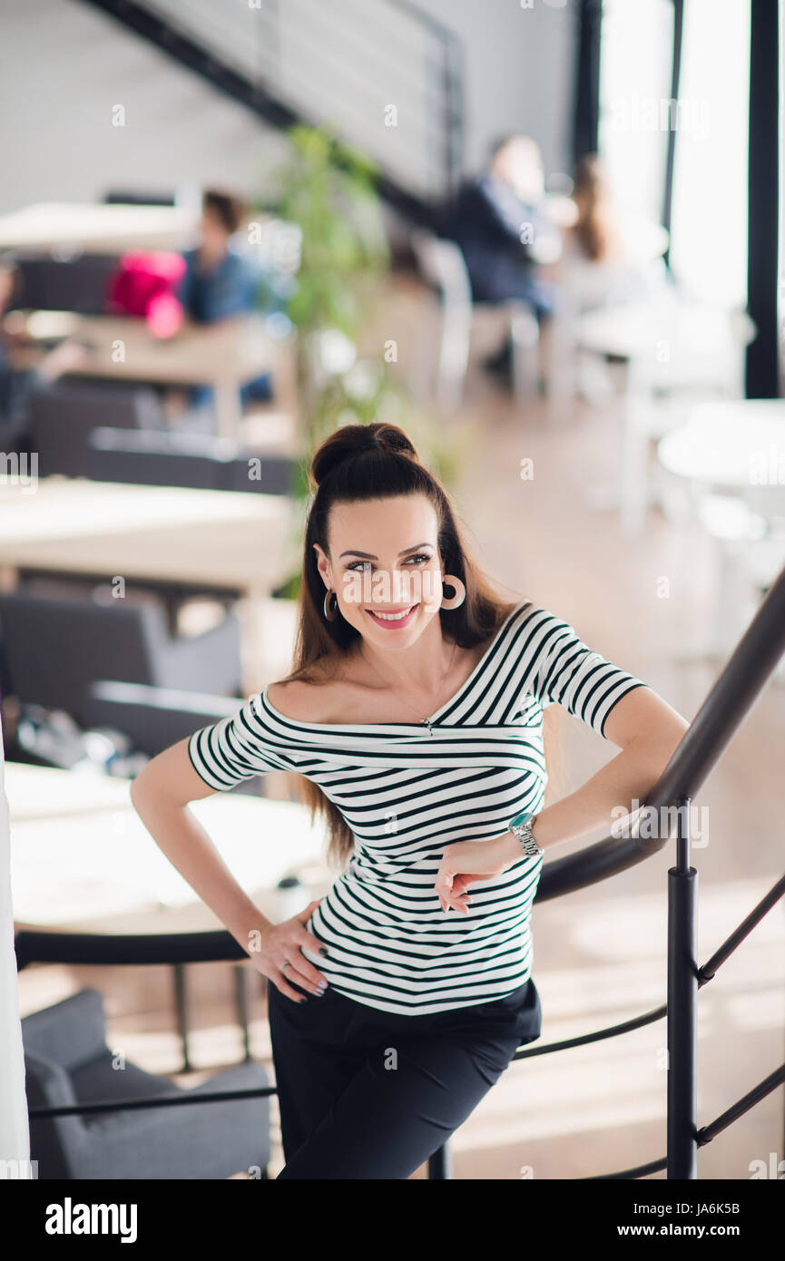 Business donna con aspetto positivo e allegro sorriso in posa per la fotocamera. Foto Stock