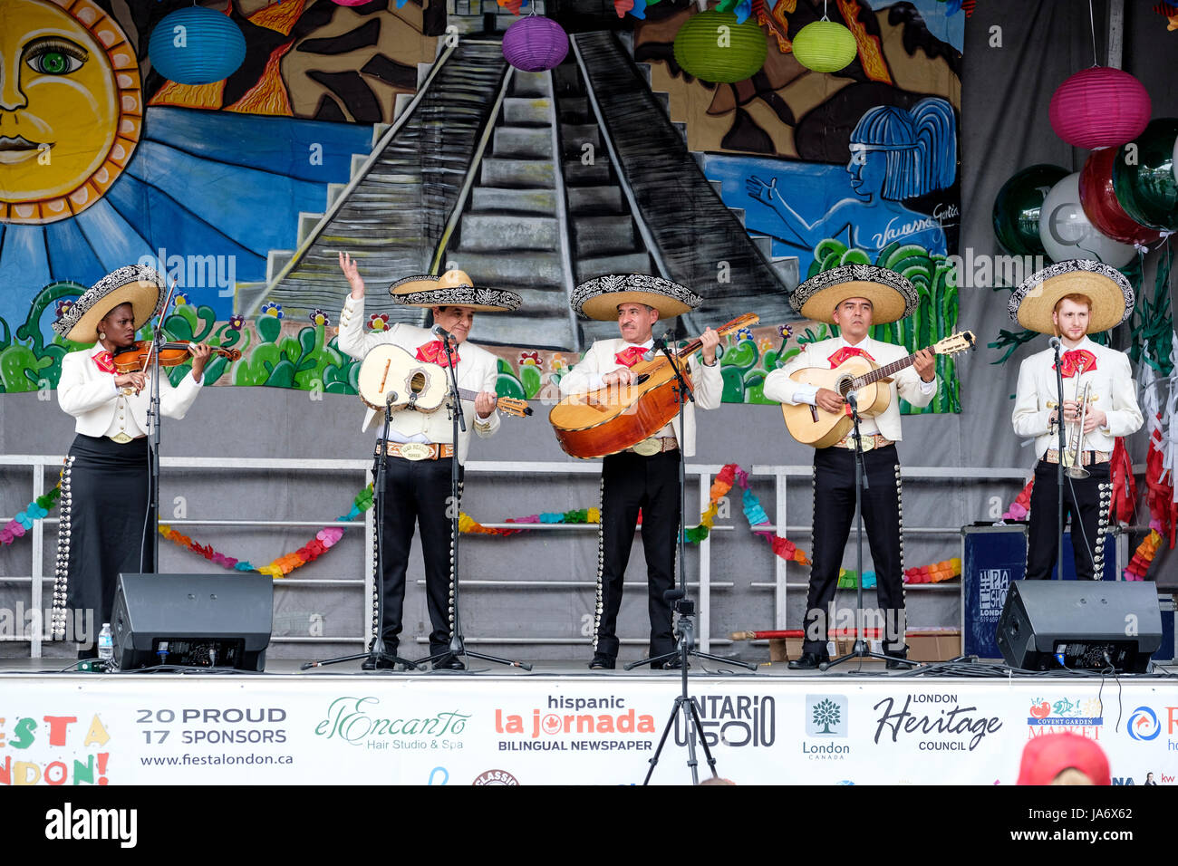 Musica dal vivo. Tradizionale gruppo mariachi che suona musica dal vivo sul palco del Fiesta London! Festival messicano, gruppo mariachi, musicisti mariachi, musica tradizionale messicana, gruppo di cinque musicisti messicani che indossano sombreros messicani e suonano strumenti mariachi. Foto Stock