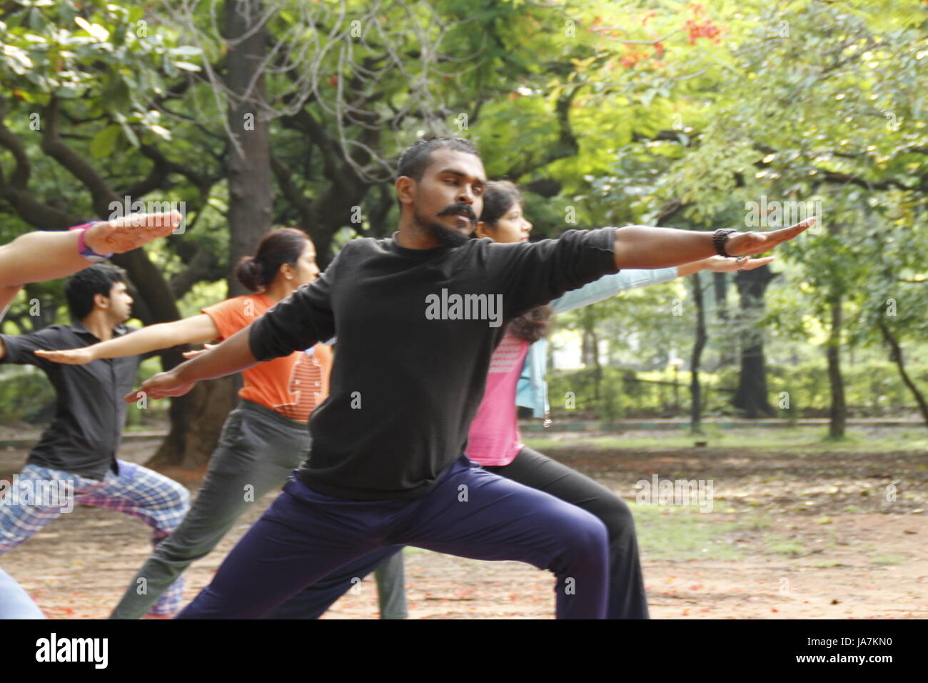 Un gruppo di giovani indiani di eseguire lo yoga in Cubbon Park, Bangalore, India Foto Stock