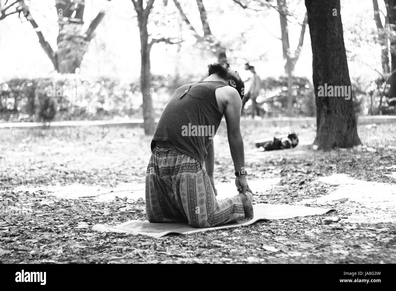 Giovane uomo indiano in cammello pongono (Ustrasana), Cubbon Park, Bangalore. Foto Stock