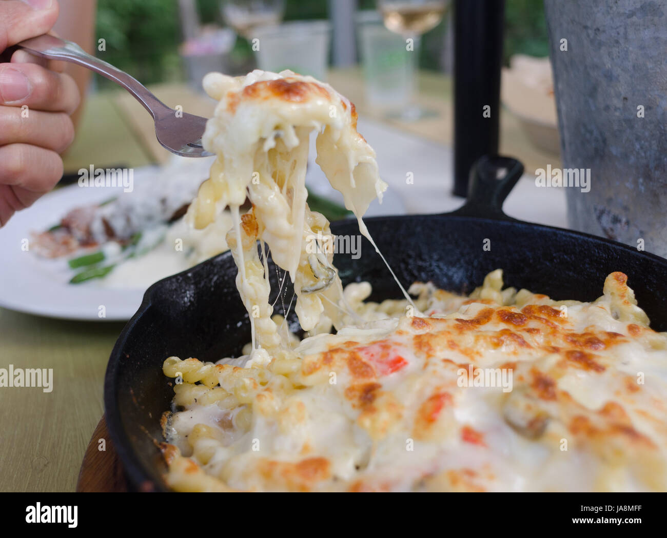 Una donna mangia mac e formaggio Foto Stock