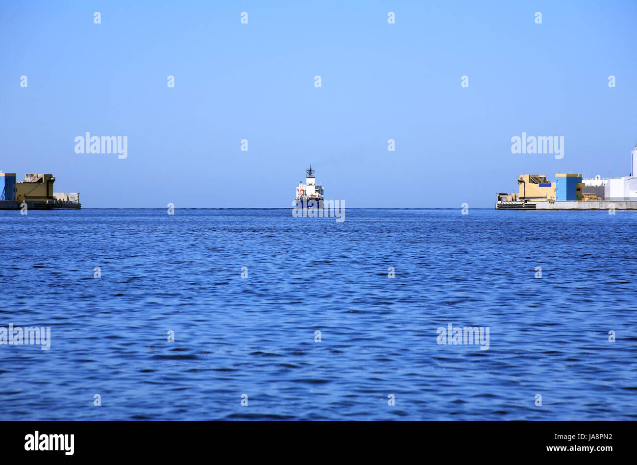 Vista Panorama con la nave da carico muovendo dal porto di mare aperto Foto Stock