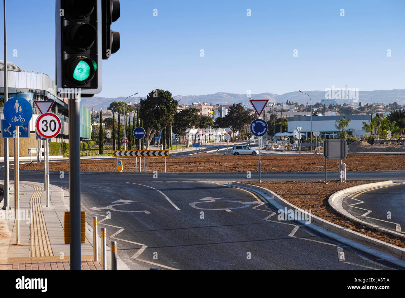 Rotonda con indicazioni stradali, semaforici e di segnaletica stradale. Scena urbana. Foto Stock