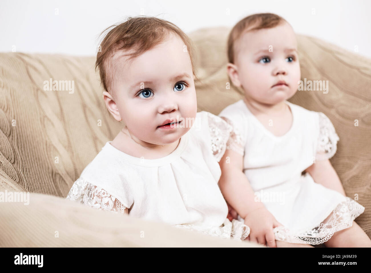 Due adorabili baby twin ragazze. Graziosi gemelli identici seduto sul pullman. Foto Stock