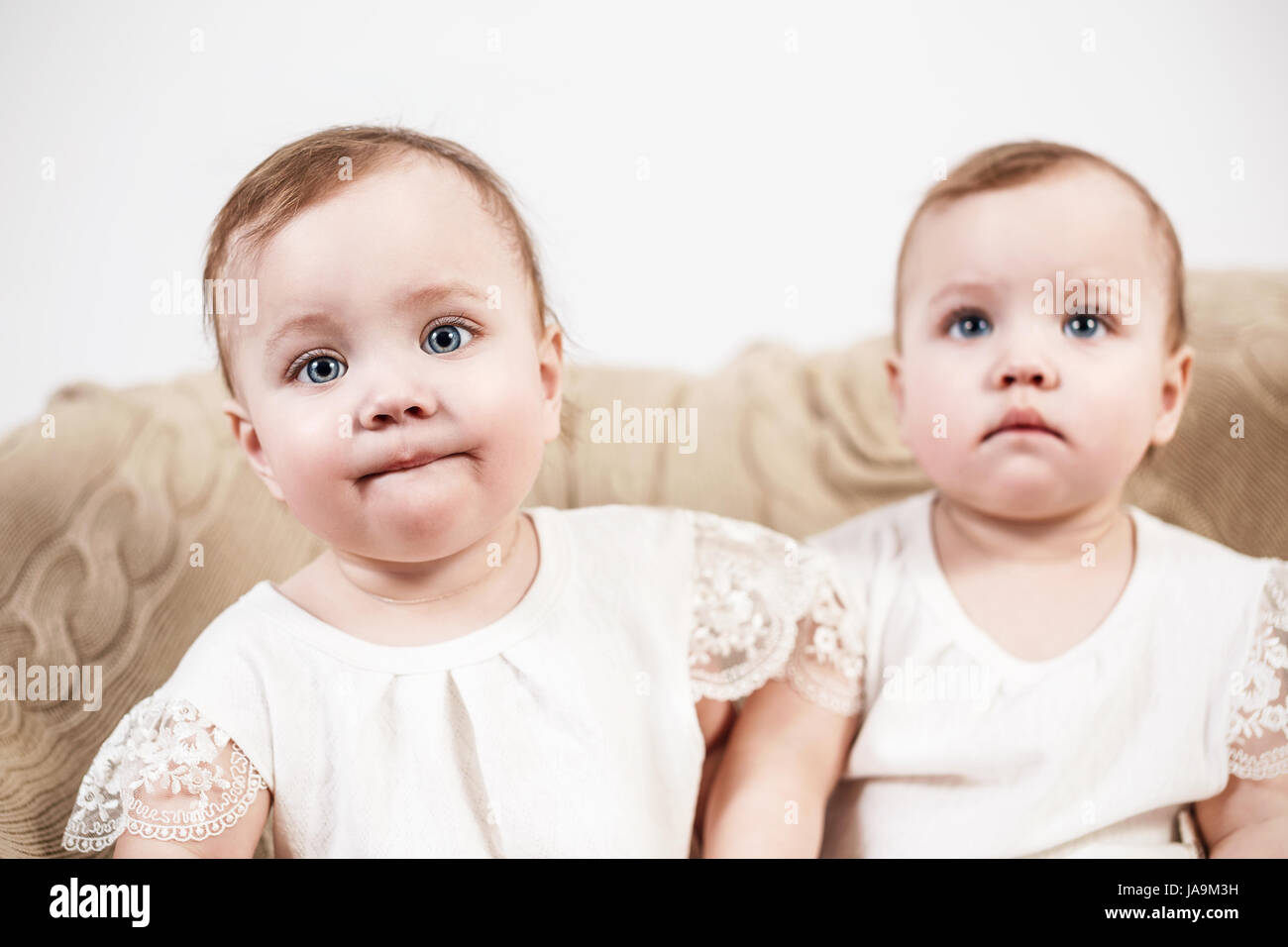 Due adorabili baby twin ragazze. Graziosi gemelli identici seduto sul pullman. Foto Stock