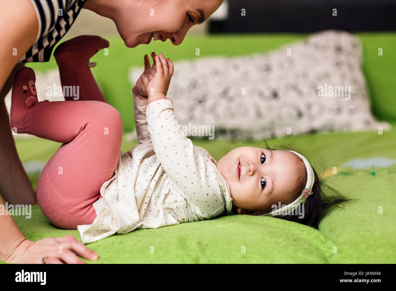 Felice giovane madre bacia poco adorabile figlia. Foto Stock