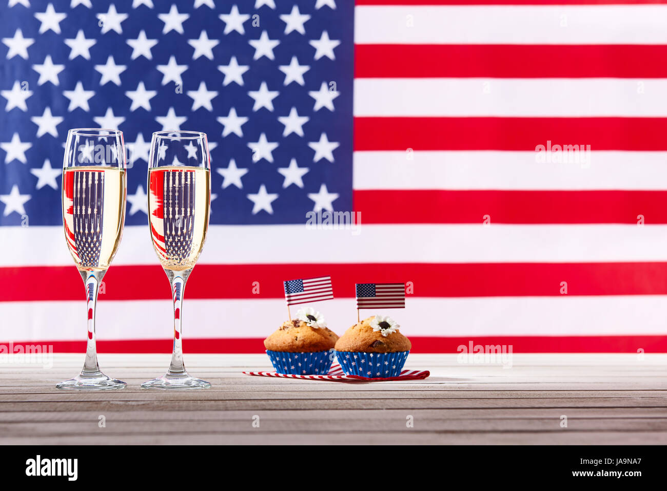 Bandiera americana, due bicchieri di champagne e carino tortine Foto Stock