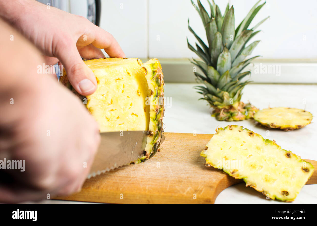 Maschio peeling delle mani di ananas fresco pelle close up Foto Stock