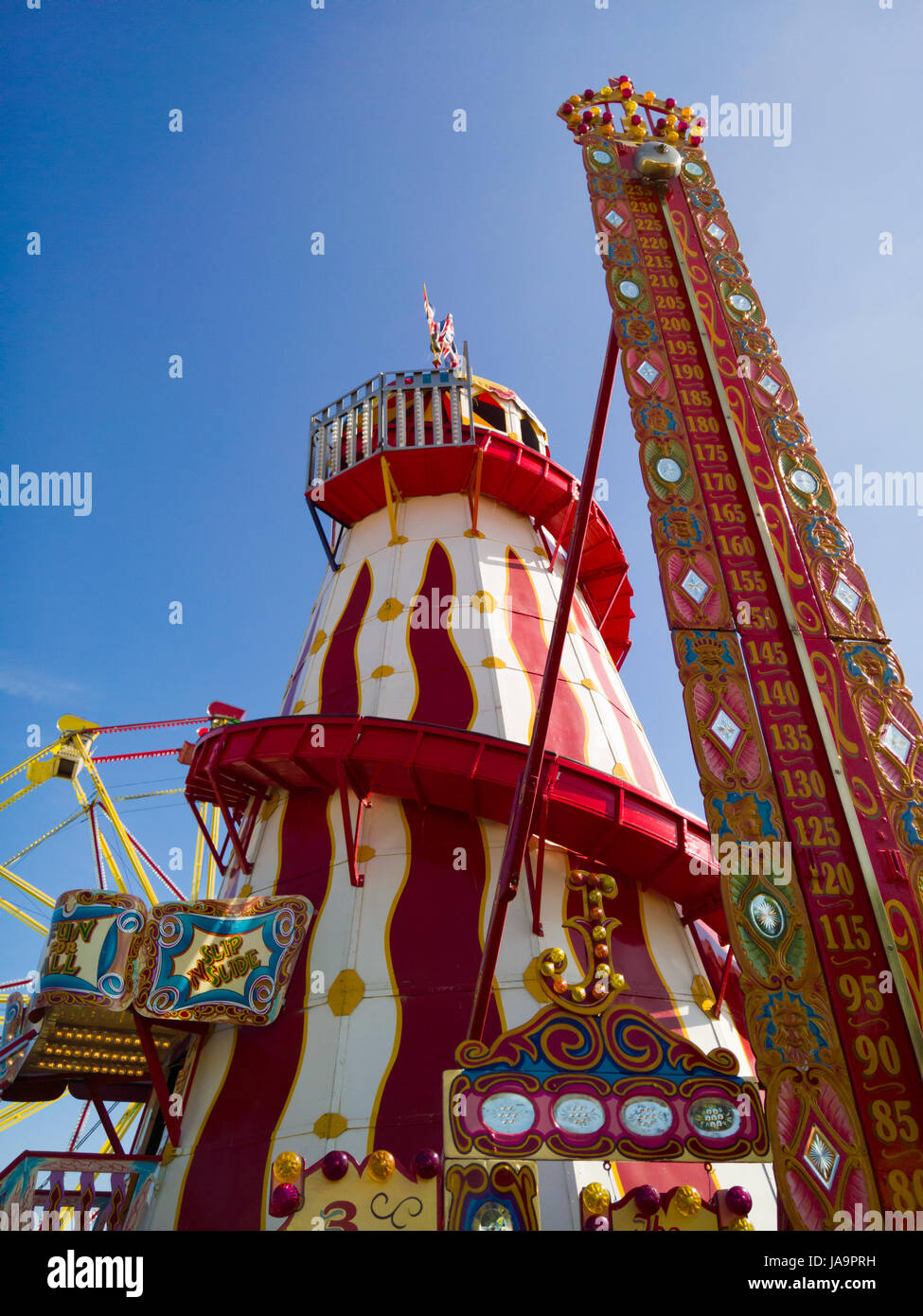 Un Helter Skelter e un elevato gioco di riscontro presso il parco di divertimenti al bagno e West Show, Shepton Mallet, Somerset, Inghilterra. Foto Stock