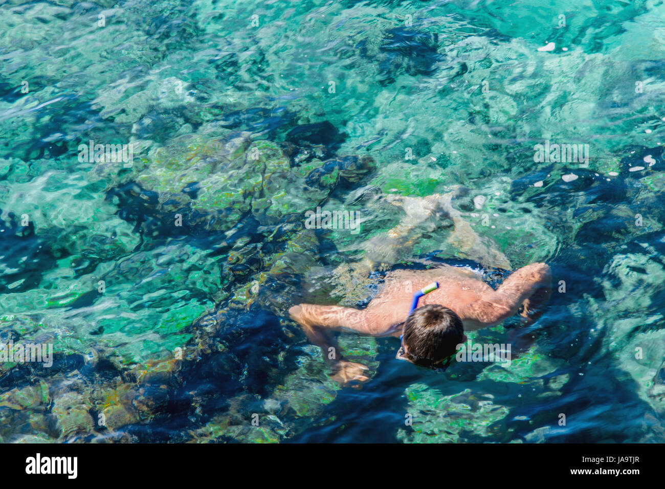 Uomo di snorkeling in acque cristalline Foto Stock