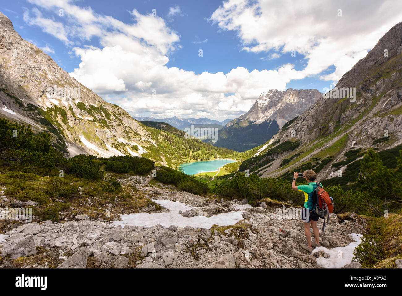 Escursionista di scattare una foto con il telefono mobile della montagna Zugspitze e il lago Seebensee, Ehrwald, Tirolo, Austria Foto Stock