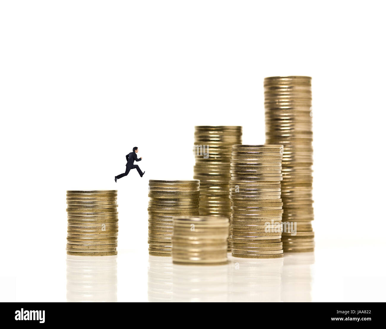 Imprenditore salta sopra il divario tra pile di monete Foto Stock