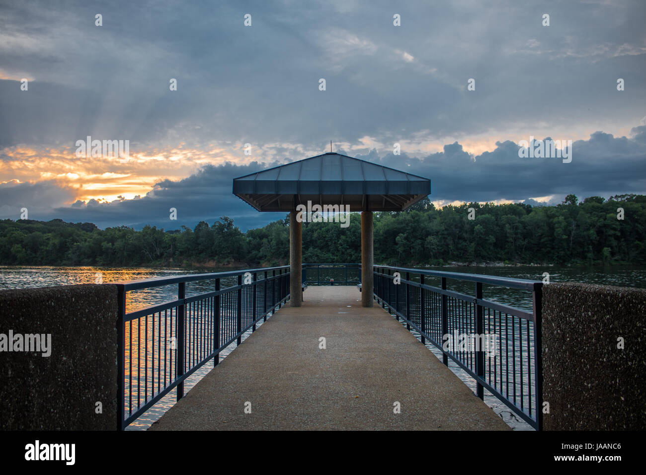 Il molo sul fiume Nuvoloso Tramonto Foto Stock