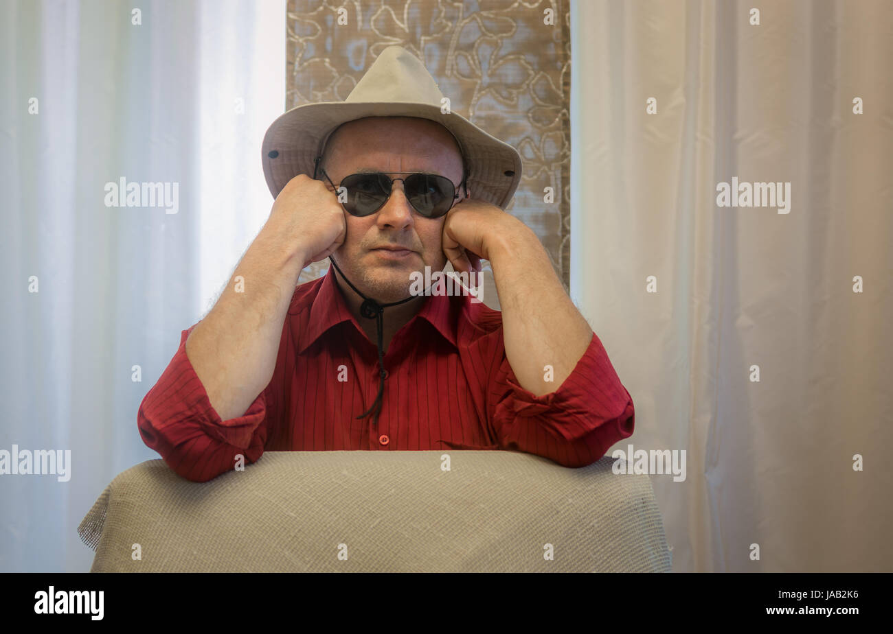 Piscina ritratto di uomo maturo che indossa un cappello e occhiali da sole nero Foto Stock