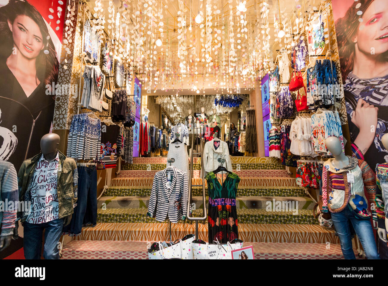 Giappone, Osaka, Shinsaibashi. Elegante negozio di abbigliamento per donna di entrata e interni. Ampia scala con centinaia di luci appese sopra in gabbie. Foto Stock