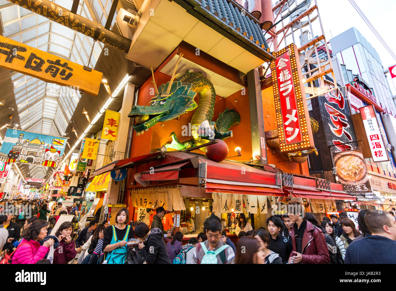 Giappone, Osaka, Dotonbori. Notte tempo. Ramen Kinryu contatore da asporto e ristorante con grandi iconico floating dragon scudo, il marchio della società. Foto Stock