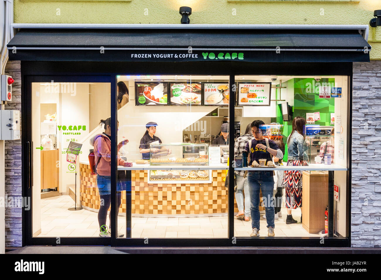 Giappone, Osaka, Shinsaibashi. Yo.Cafe, yogurt congelato e coffee shop, i clienti e il contatore principale visto attraverso il vetro anteriore. Foto Stock