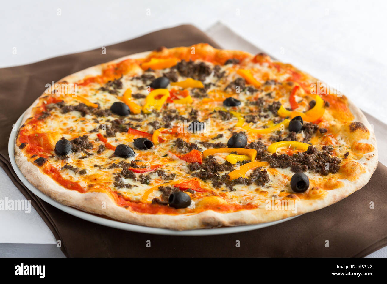 Una Pizza Con Peperoni Mozzarella Pomodori Olive Cotte In Fuochi Di Legno E Serviti In Un Ristorante Su Una Piastra Bianca Questa Ricetta E Tipicamente Italiano Foto Stock Alamy