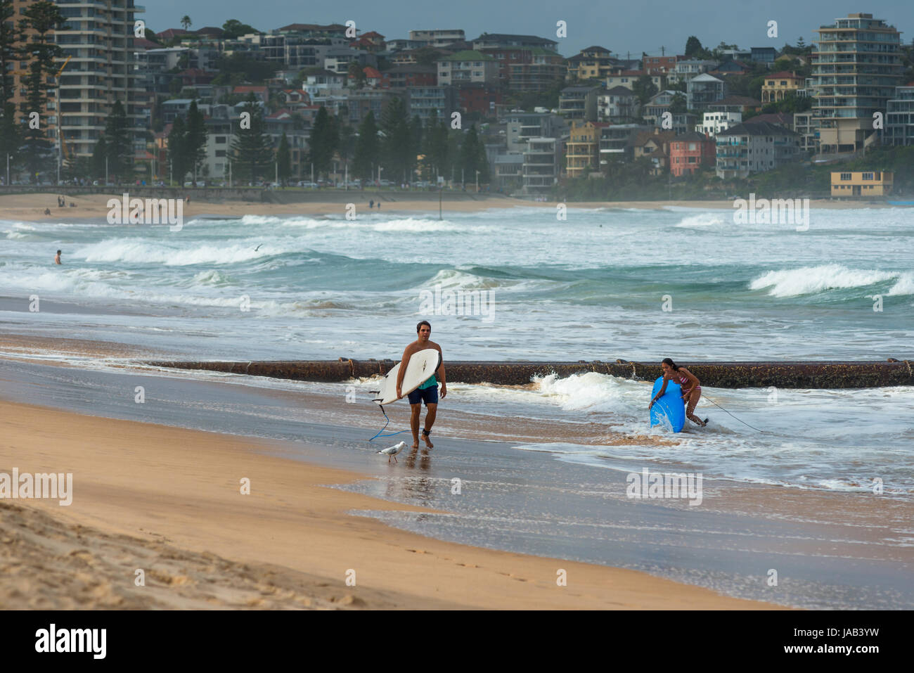 Surfisti a Manly Beach in un giorno di tempesta. Periferia nord di Sydney, NSW, Australia. Foto Stock