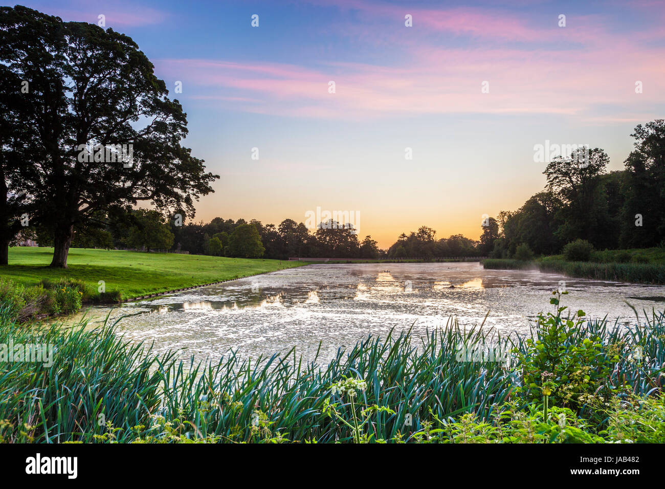 Un estate alba sul lago a Lydiard Park a Swindon, Wiltshire. Foto Stock