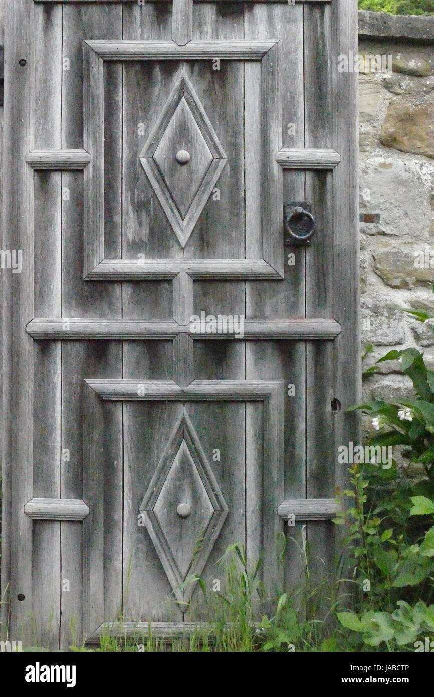 Antica porta di legno in giardino murato. Foto Stock