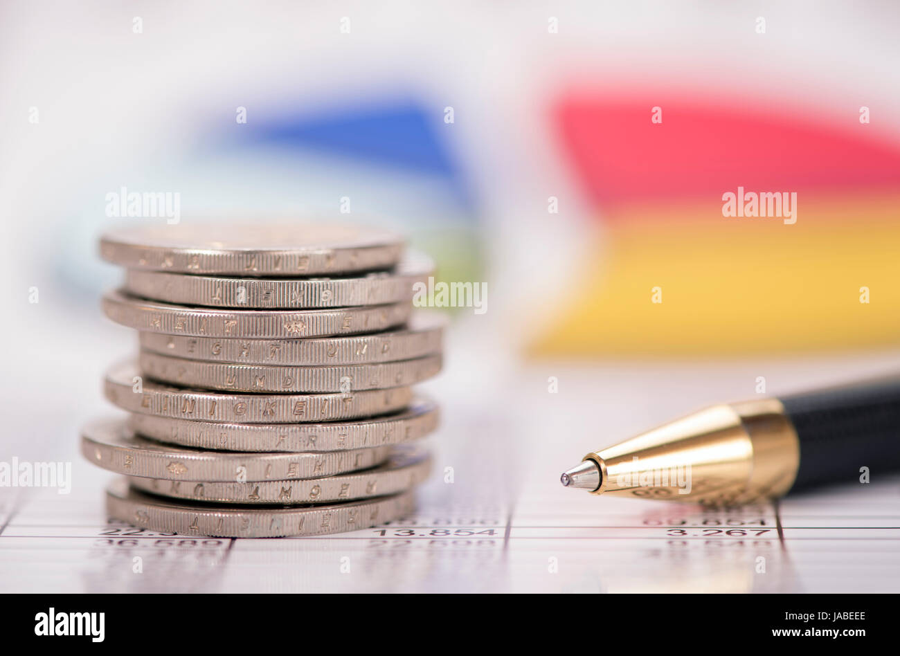 Impilati monete in euro sul foglio della tabella con il grafico del mercato dei cambi Foto Stock