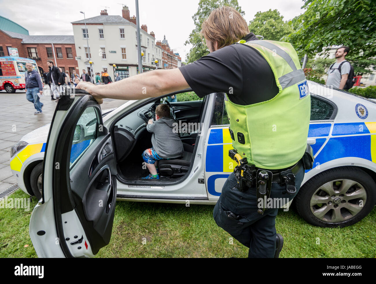 Coventry Motofest 2017 poliziotti prendere tempo con i bambini per mostrare l'interno di un'auto della polizia. Foto Stock