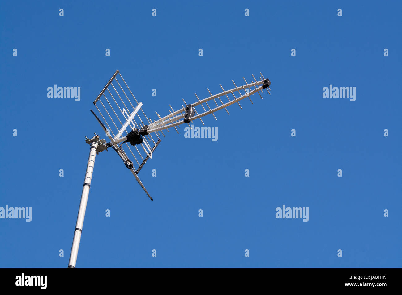 Antenna TV sulla casa contro il cielo blu e chiaro. Regno Unito. Foto Stock