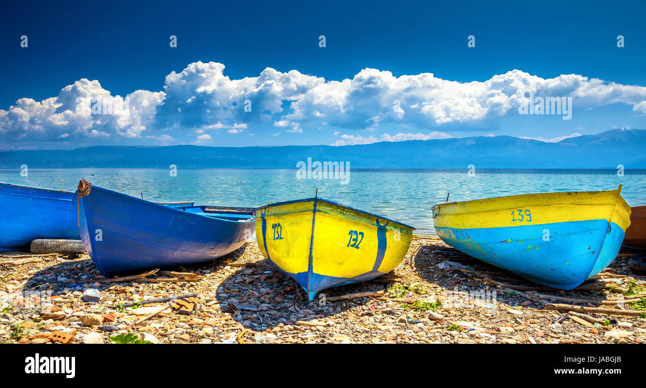 Barche colorate sulla spiaggia al lago di Ohrid con cielo nuvoloso, Albania. Foto Stock