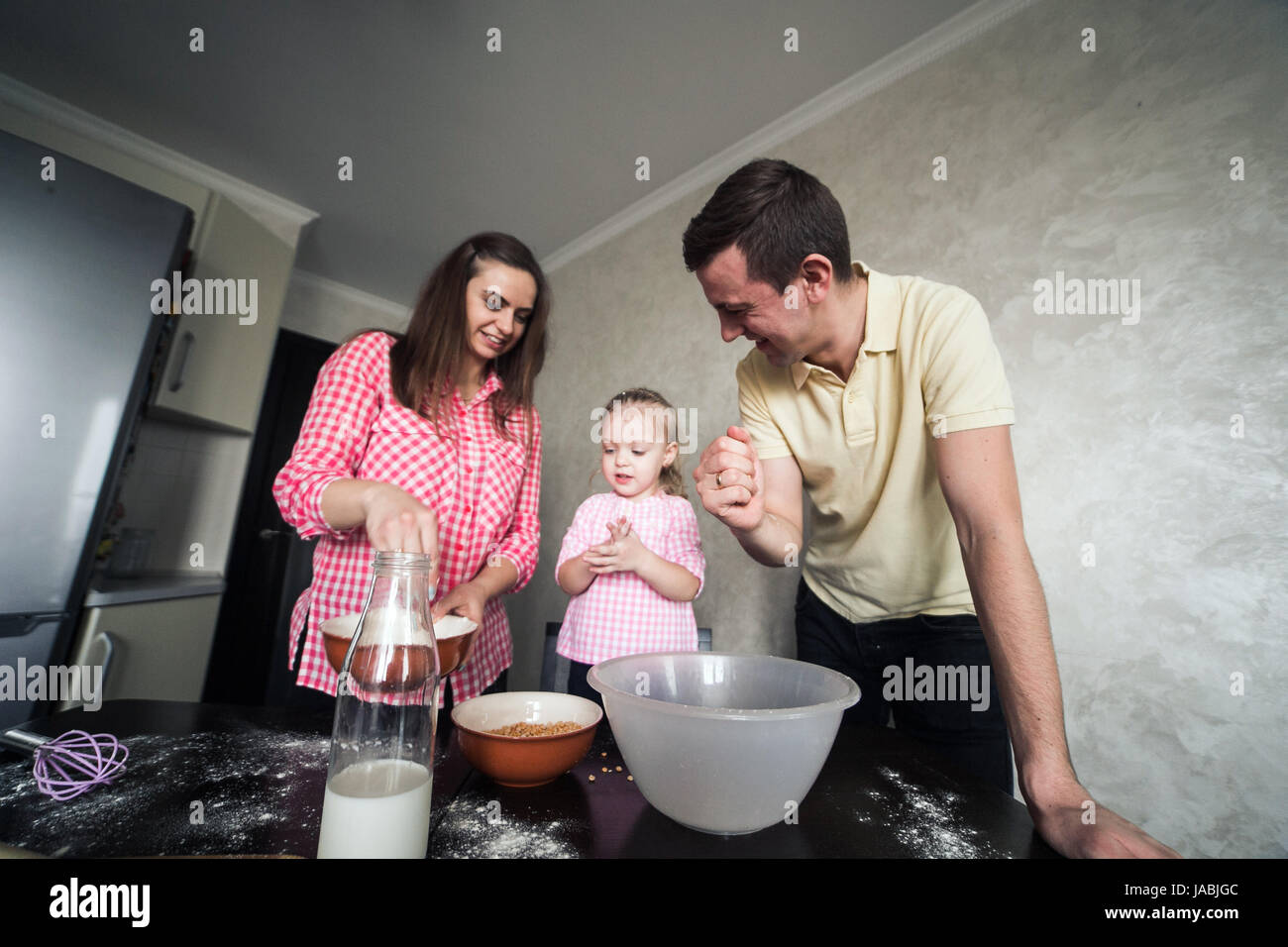 Papà, mamma e figlia insieme in cucina Foto Stock