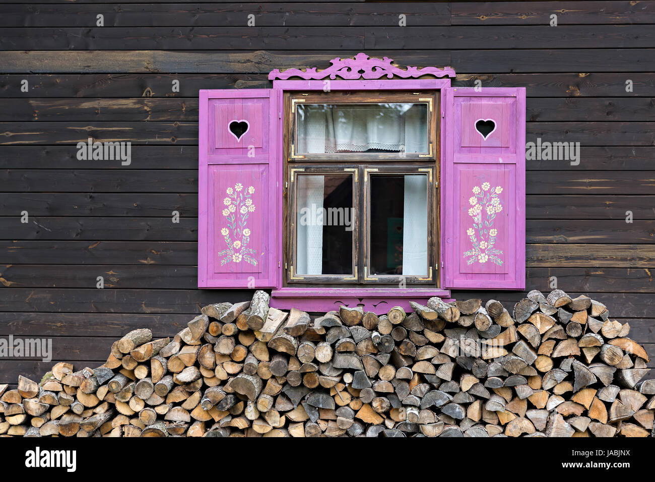 Rosa ha aperto le persiane della vecchia casa in legno Foto Stock