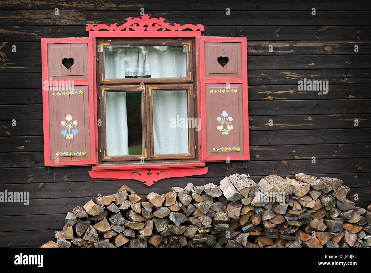 Red ha aperto le persiane della vecchia casa in legno Foto Stock