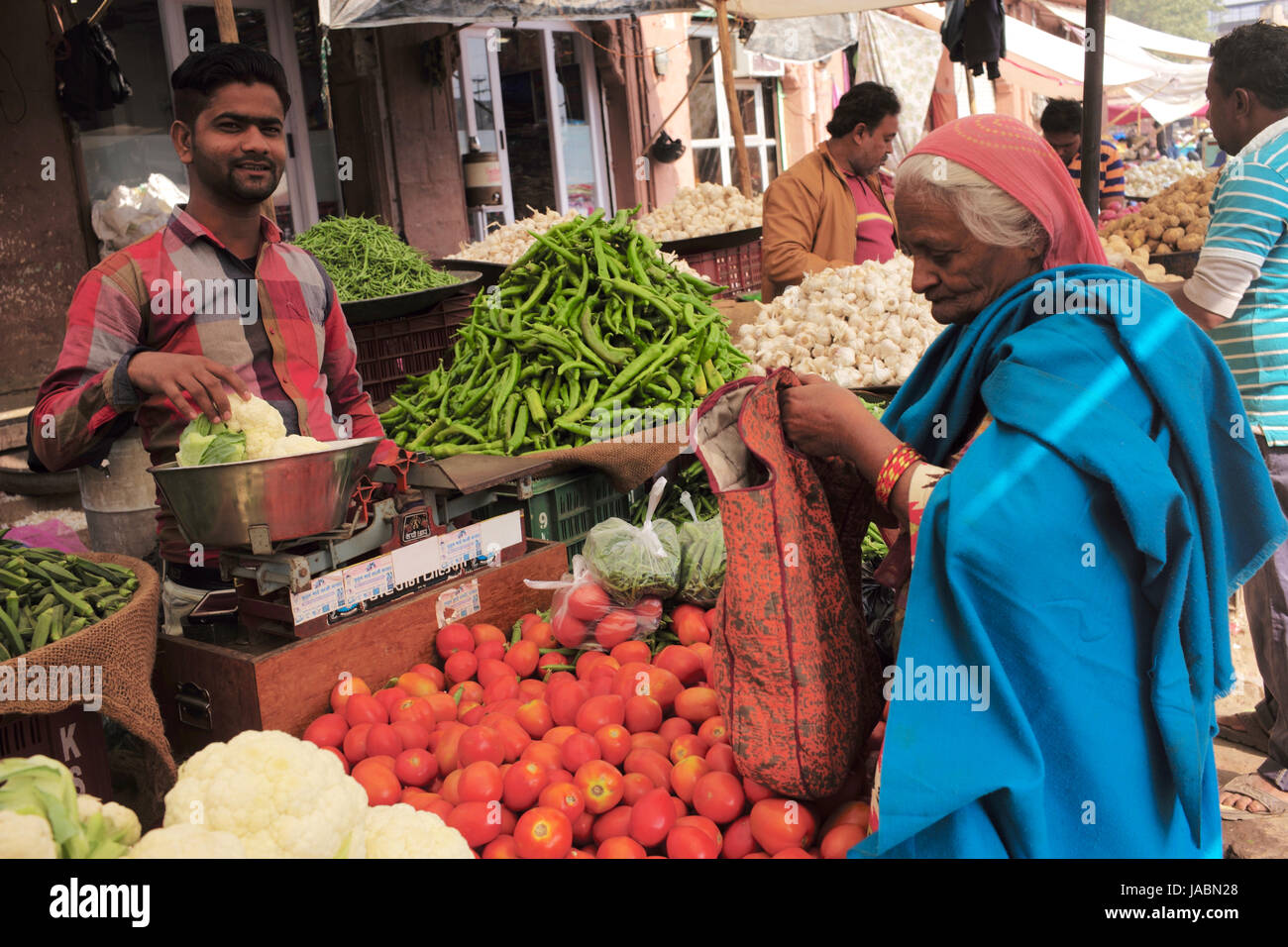 Vecchia donna acquistare verdure a Indian street market Foto Stock